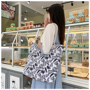 Ethnic style large tote bag with parrot print and braided rope handle in bakery setting