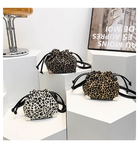 Three leopard print drawstring bucket bags in various brown shades on white display stands
