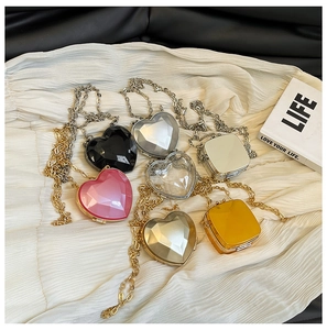 Flat lay of mini heart and square acrylic chain bags in various metallic and pastel colors