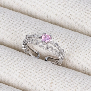 Detail of pink heart-shaped zirconia ring with silver band in a beige jewelry box