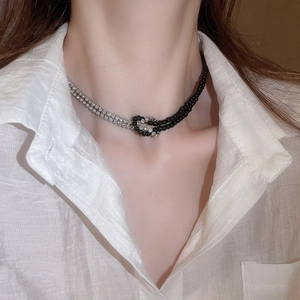 Dettaglio della collana stile Y2K con catena in diamanti argento e perline nere su modella