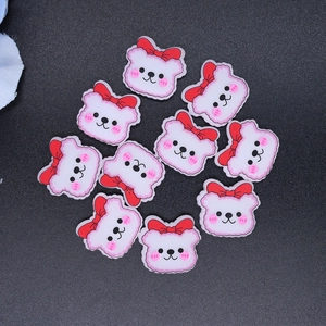 Detailed view of white and pink resin bear charms with red bows for DIY crafts