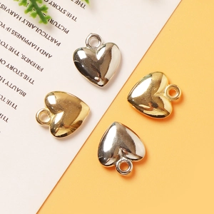 Golden and silver heart pendants for DIY jewelry making on a minimalist backdrop