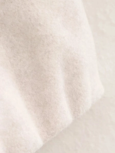 Gros plan sur la texture cachemire douce et les fibres d'un blouson aviateur blanc