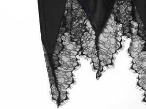Detailed close-up of intricate black eyelash lace patchwork on irregular hemline skirt