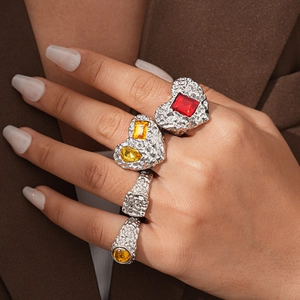 Detailed shot of resin heart rings with vibrant gemstones and silver hammer texture finish