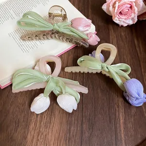 Three elegant acrylic tulip hair claws in pink, white and purple with satin ribbon detail