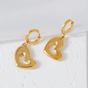Boucles d'oreilles cœur doré en acier inoxydable pour femme sur fond de soie blanche