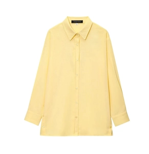 Détail du col d'une chemise en lin jaune montrant la texture fine et les plis soignés