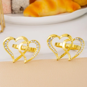 Close-up of luxury gold heart napkin rings with crystal diamonds for table decor