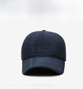 Close-up of quilted navy blue winter cap with rhombus pattern and embroidered logo detail