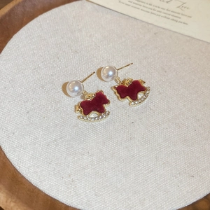 Close-up of red flocked rocking horse earrings with pearls and sparkly rhinestones