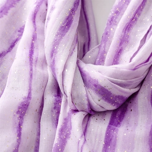 Detailed macro shot of purple gradient scarf fabric with shiny gold foil accents
