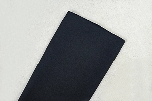 Close-up of fine textured black fabric showing detailed knit pattern on backless dress