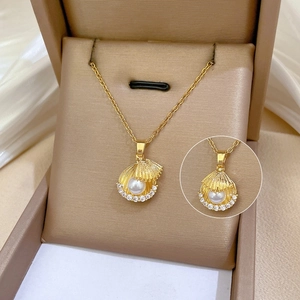 Détail du collier pendentif coquille dorée avec perle et zircon dans son écrin