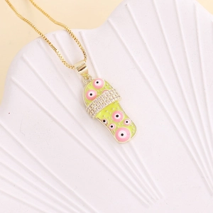 Close-up of golden flip-flop necklace with yellow-green enamel and sparkling crystal accents