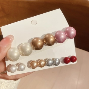Set of seven pairs of round pearl stud earrings in white gold pink and red colors