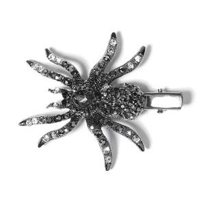 Detail of a spider-shaped metal hair clip encrusted with sparkling rhinestones and duckbill grip