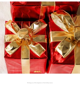 Detail of red metallic Christmas gift boxes with elegant golden satin bows and ribbons