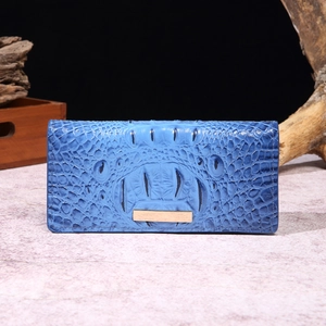 Detail of dark blue crocodile embossed long wallet with golden metal decorative plate