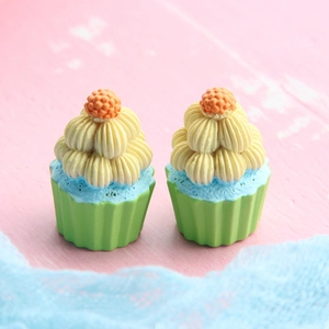Macro shot of two resin miniature cupcakes with colorful frosting for DIY crafts
