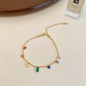 Close-up of golden bead chain bracelet with colorful geometric gemstones and lobster clasp