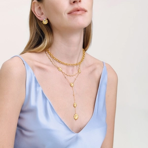 Détail d'un collier doré à 3 couches avec marguerites, zircon blanc et métal brossé