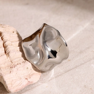 Detail of silver hammered texture ring on natural stone with polished finish