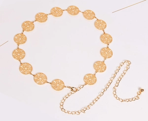 Detail of golden metal chain belt with hollow floral circular links and adjustable extension