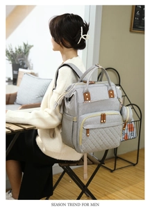 Detail view of grey multifunctional diaper backpack with quilted pattern and side pouch