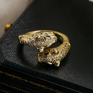 Detailed view of 18K gold leopard ring with green gemstone eyes and white cubic zirconia