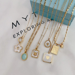 Collection of gold titanium steel necklaces with butterfly and heart charms on display