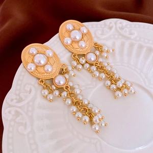 Elegant vintage oval pearl tassel earrings with gold metal accents on a luxury silk backdrop