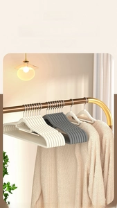 Detail of non-slip flocked hangers in beige and grey prevent shoulder bumps on knitwear