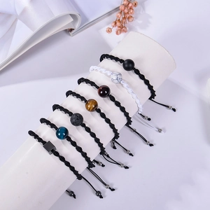 Adjustable woven bracelet set with white turquoise and black magnetic stones on display stand