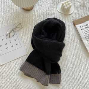 Macro detail of soft black and grey knitted scarf showing premium wool blend texture