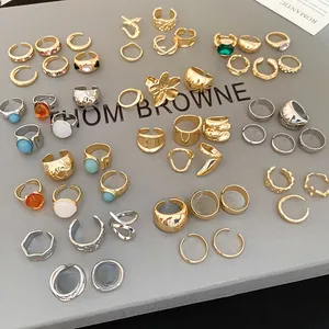Close-up of geometric irregular metal rings and ear cuffs in gold and silver finishes