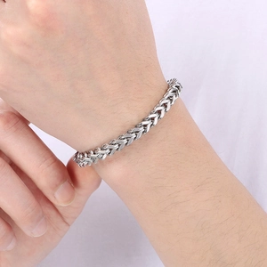 Close-up of a silver stainless steel wheat chain bracelet on a male wrist