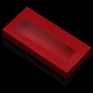 Macro view of red glitter eyelash box featuring a clear window and textured finish