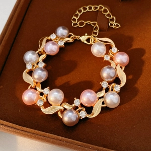 Vue macro d'un bracelet doré vintage avec perles roses et strass dans un coffret