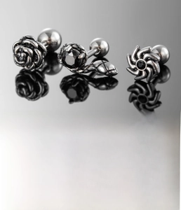 Detailed close-up of retro silver stainless steel snake and rose stud earrings with zircon