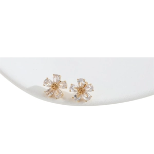 Elegant gold flower stud earrings with five pear-shaped zircon petals on a white pedestal