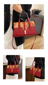 Close-up of red embossed leather bag with artistic patterned flap and gold clasp
