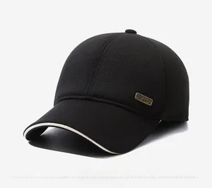 Detail of winter baseball cap showing metal logo, black corduroy texture, and white brim trim
