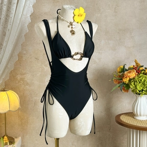 Detail of black bikini with gold heart ring and adjustable side drawstring ties