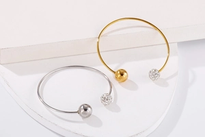 Détail de bracelets joncs minimalistes en forme de C avec strass brillants et billes en métal