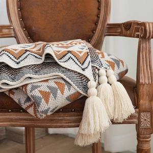 Macro shot of thick knitted bohemian throw blanket with geometric patterns and tassels