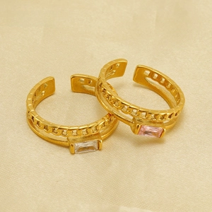 Macro detail of gold-plated hollow chain rings with square white and pink zircons