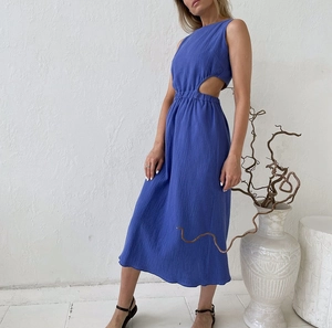 Detail of royal blue sleeveless dress featuring waist cutout and textured crepe fabric