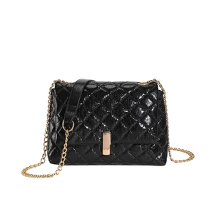 Glossy black quilted crossbody bag with gold chain strap and metallic clasp on white background